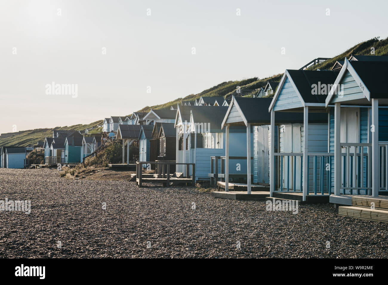 Milford on Sea, Großbritannien - 13 Juli 2019: Umkleidekabinen am Strand bei Sonnenuntergang in Milford on Sea, einem traditionellen englischen Dorf, das bekannt ist für atemberaubende Klippen geht mit Stockfoto