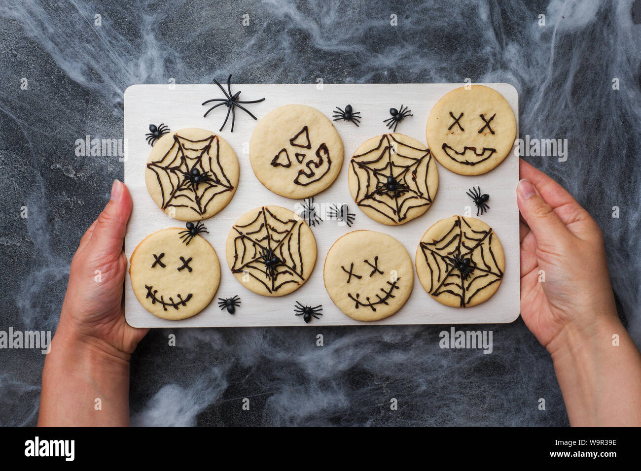 Hausgemachte Kekse für Halloween. Cookies mit lustigen Gesichtern und Spinnweben Stockfoto