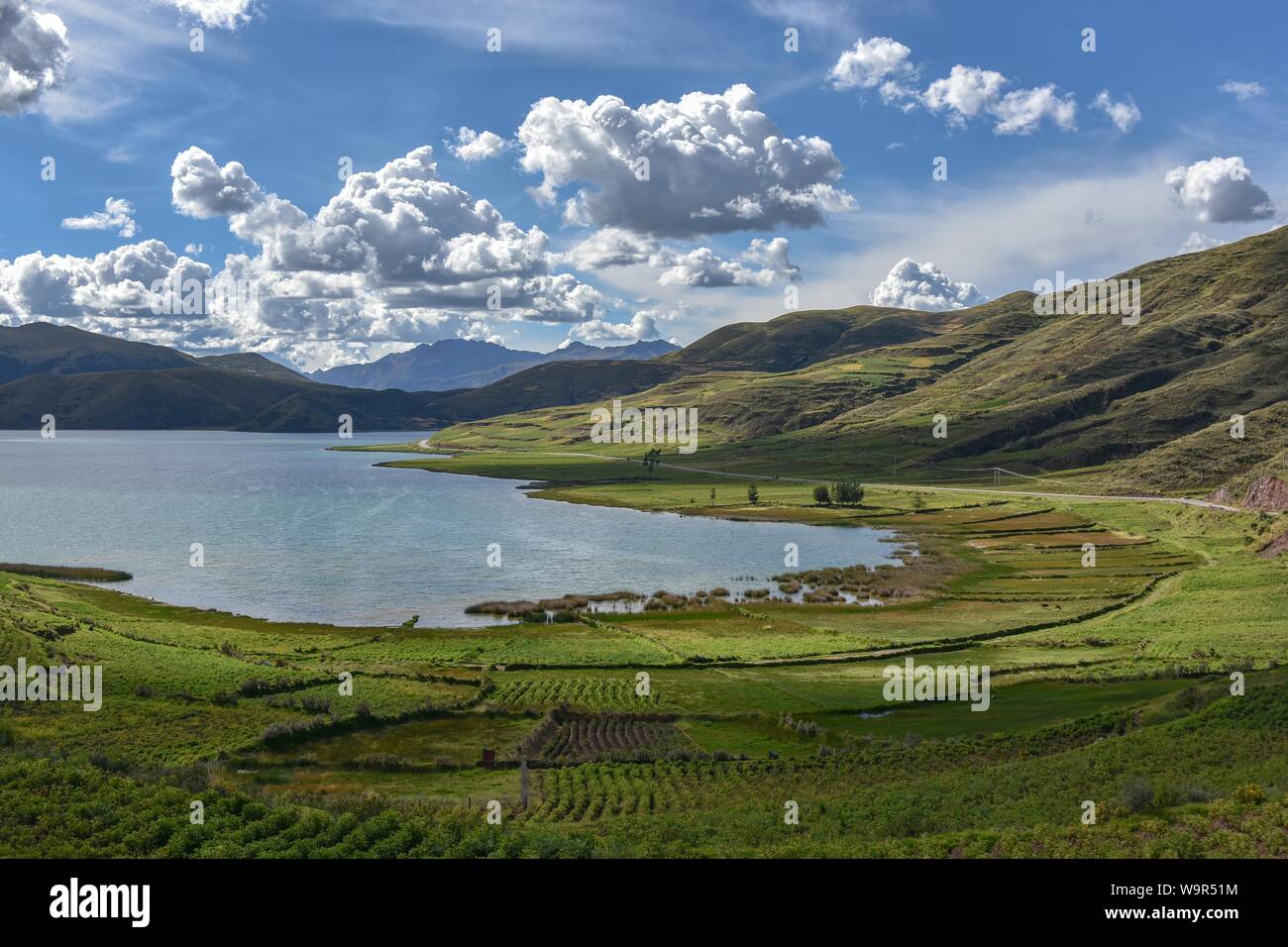 Grüne Felder im Hochland mit dem Laguna Asnacocha, in der Nähe von Cusco, Peru Stockfoto
