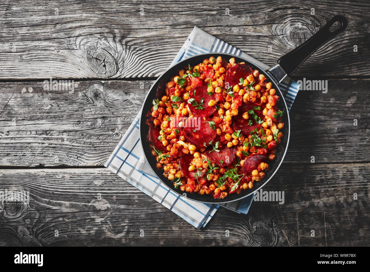 Kichererbsen fritos, frittierte Kichererbsen mit Chorizo, Schinken und Gewürzen in einer Pfanne, horizontale Ansicht von oben, flach, close-up Stockfoto