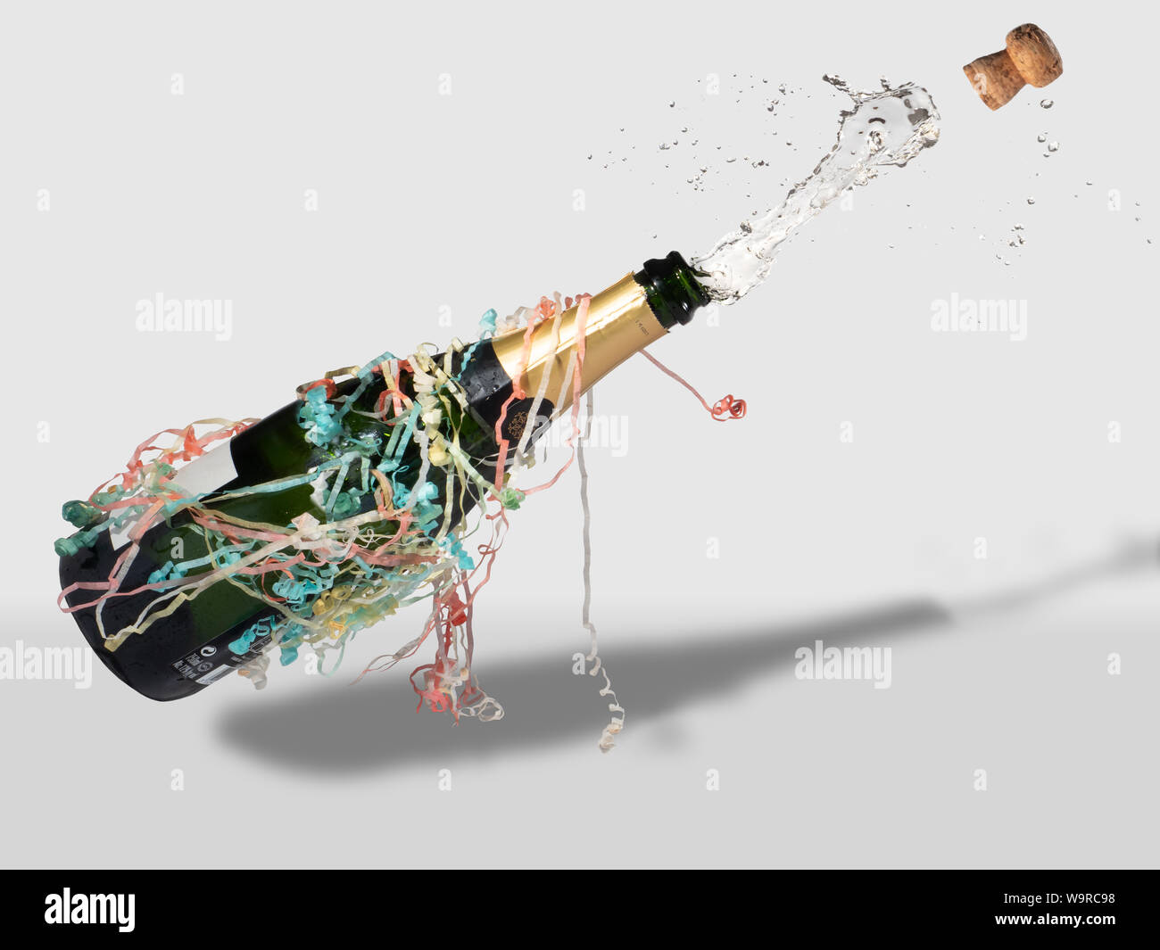 Champagner Flasche mit Streamer knallen öffnen, Kork behängt und trinken Fliegen Stockfoto
