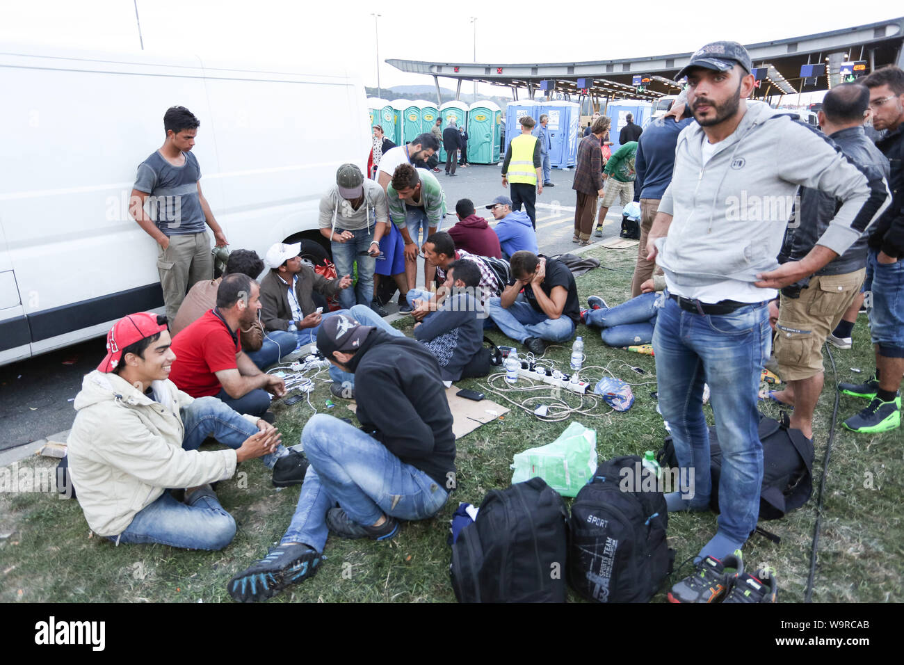 Bregana, Slowenien - 19. September 2015: eine große Gruppe von männlichen syrische Flüchtlinge ihre Handys aufladen an der slowenischen Grenze mit Kroatien. Die Stockfoto