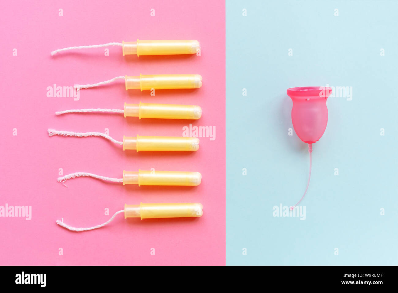 Der weibliche Menstruationszyklus Cup ist mit sechs Tampons in den Applikatoren kontrastiert. Stockfoto