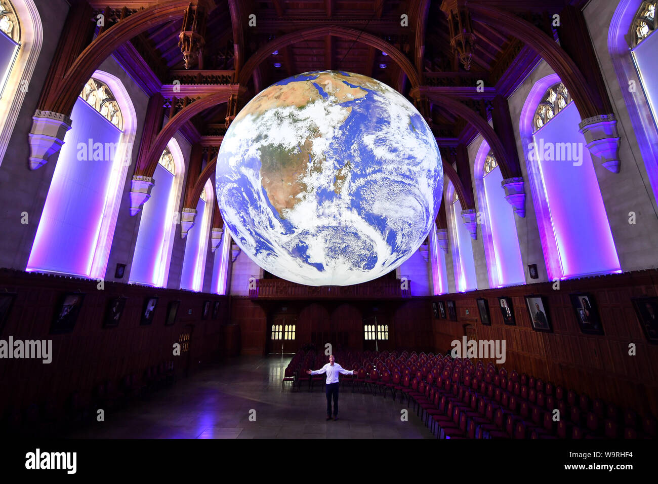 Künstler Luke Jerram steht unter seinem mächtigen Art Installation "Gaia", 7 Meter im Durchmesser und besteht aus unglaublich detaillierte NASA-Bild von der Oberfläche der Erde, wie es in der Großen Halle an der Universität von Bristol hängt. Stockfoto