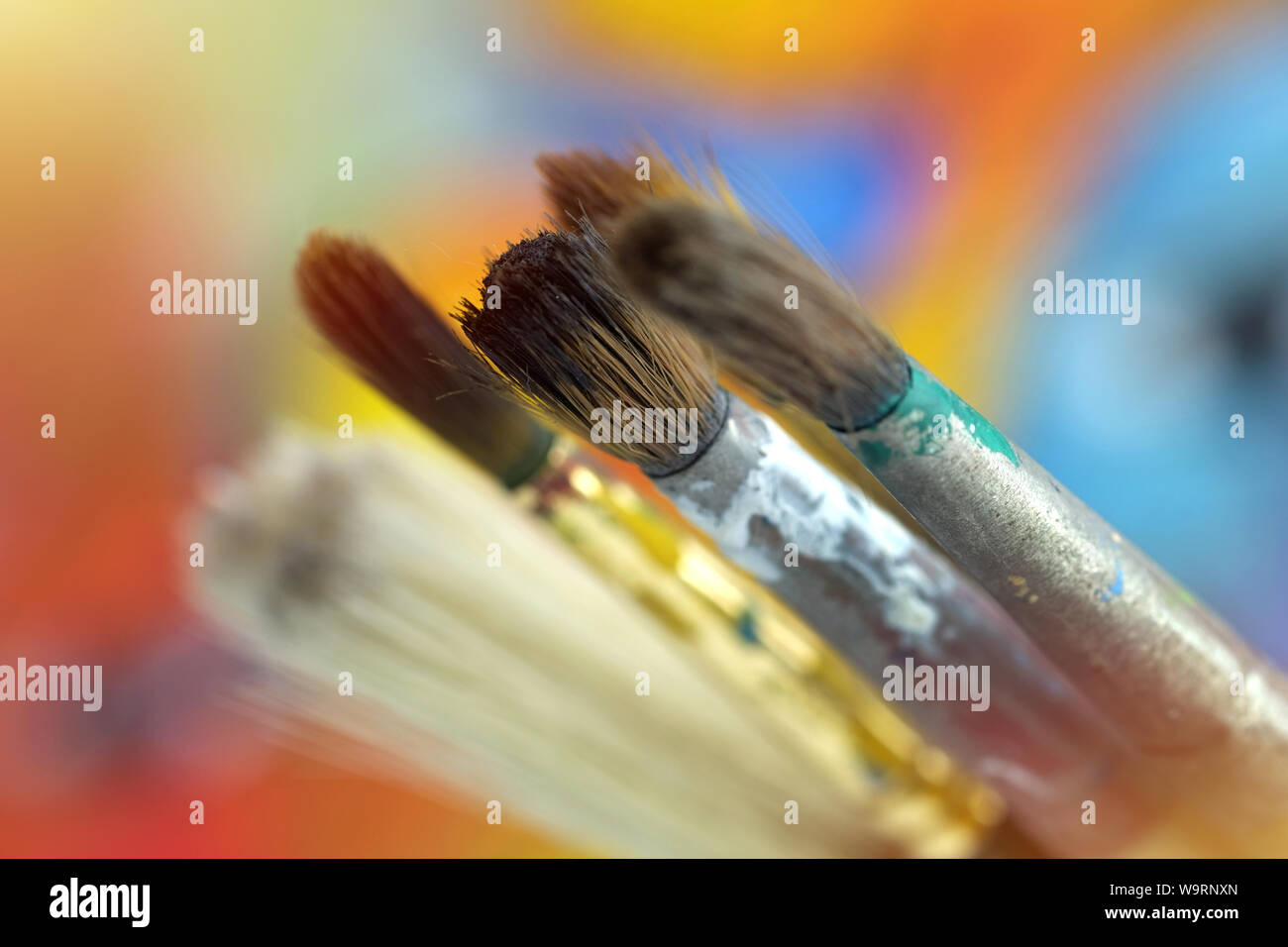 Schließen Sie einen Pinsel, Farbe, Künstler auf unscharfen Hintergrund Stockfoto