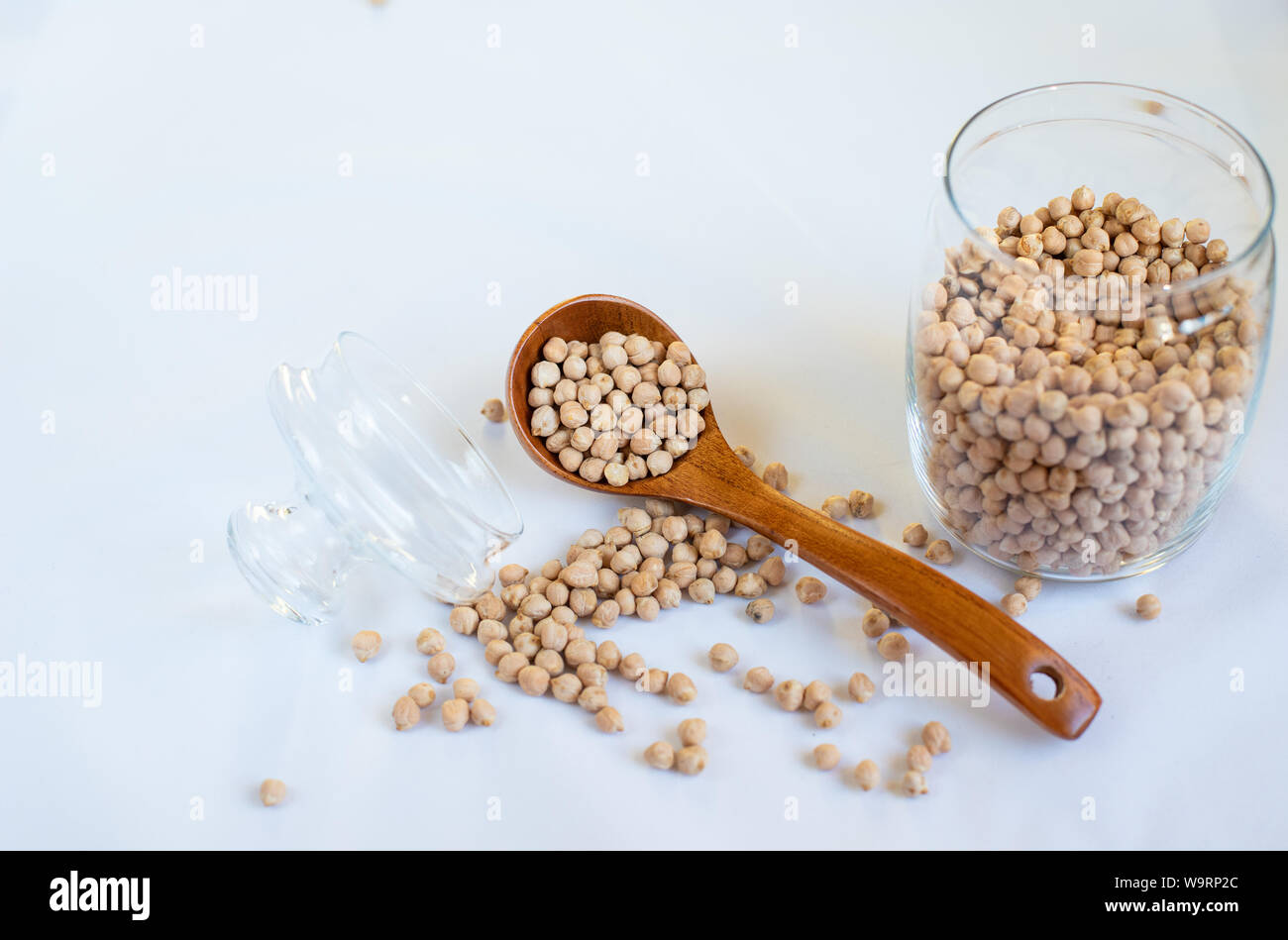 Kichererbsen in einem Glas mit einem Löffel aus Holz auf einem rosa Hintergrund Kopie Raum Text Stockfoto