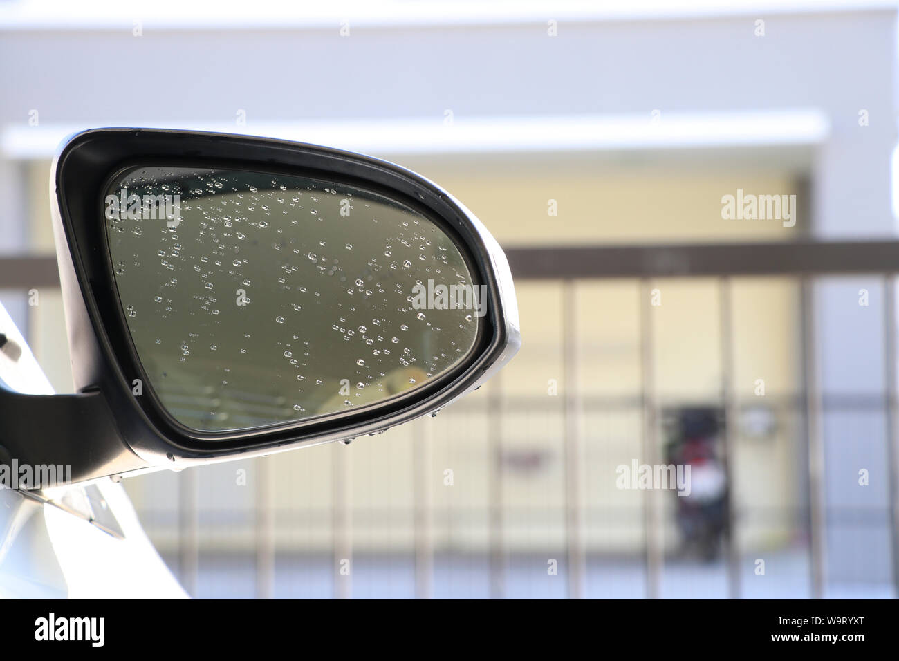Die Außenspiegel des Autos mit Tropfen Wasser auf das Glas. Auto