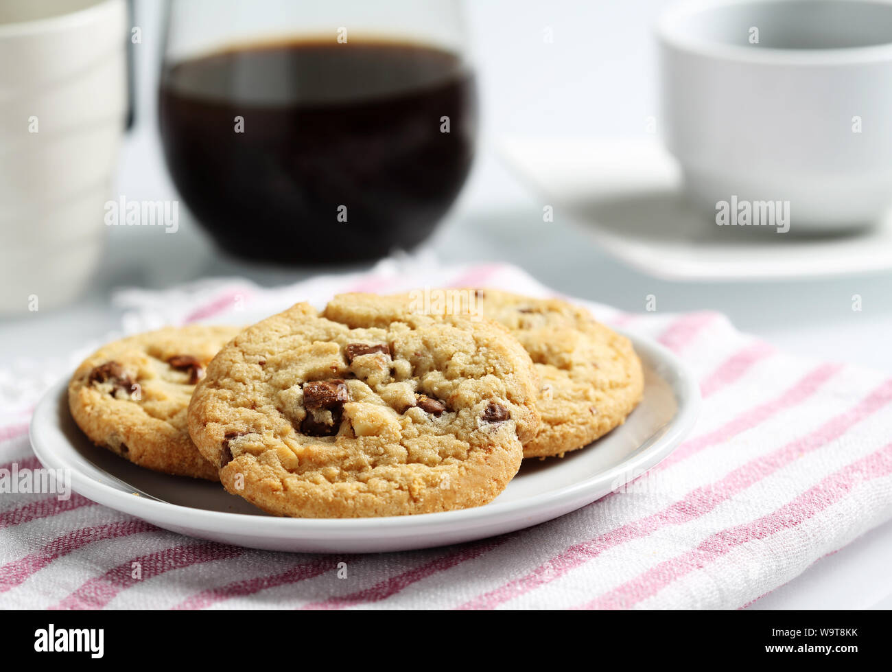 Die Chocolate Chip Cookies auf Teller und Macadamia für Kaffeepause eingestellt Stockfoto