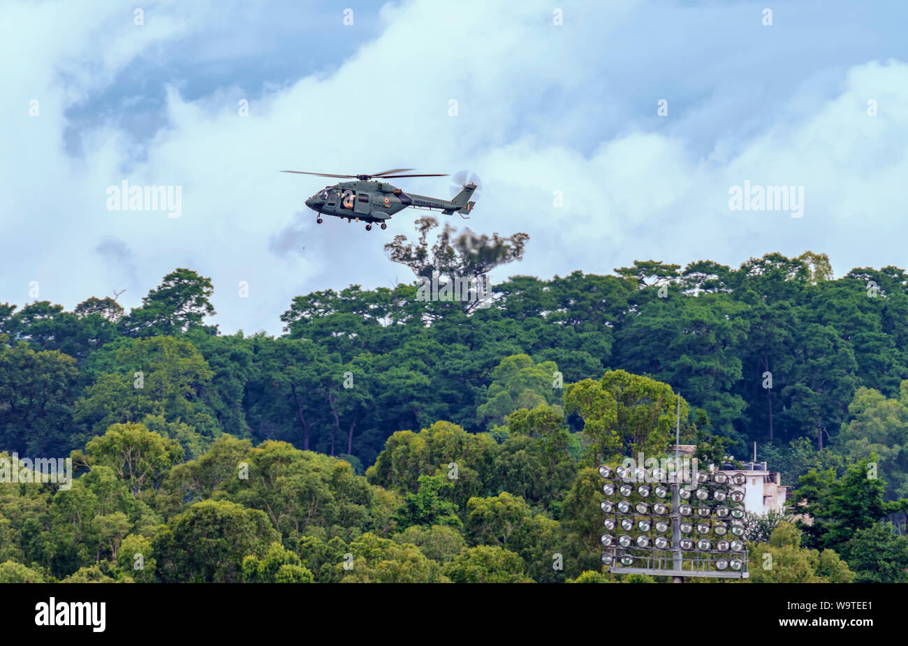 Ein Helikopter der indischen Luftwaffe, der sich vorbereitet, Blütenblätter auf die Menschen zu fallen, die sich auf dem Boden versammelten, um den indischen Unabhängigkeitstag zu feiern. Stockfoto