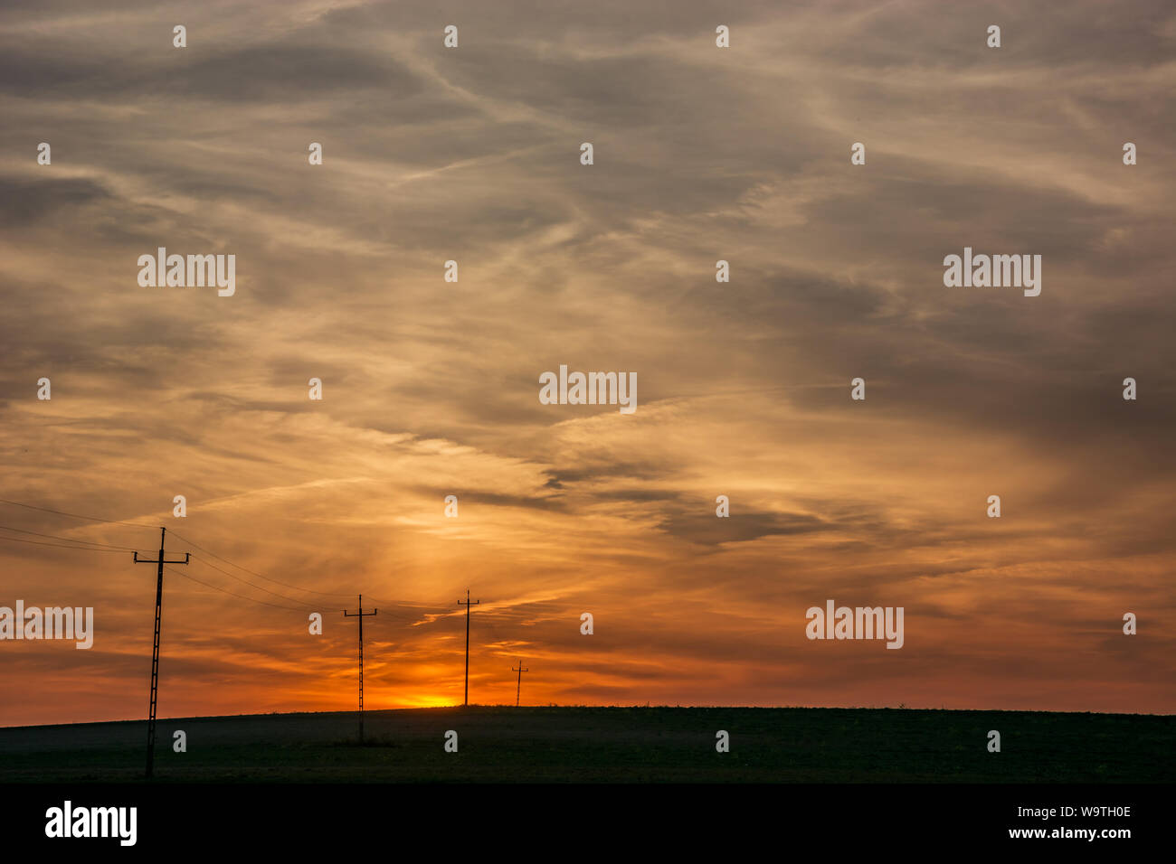 Elektrischen Polen im Feld, Himmel und Wolken nach Sonnenuntergang. Staw, Polen Stockfoto