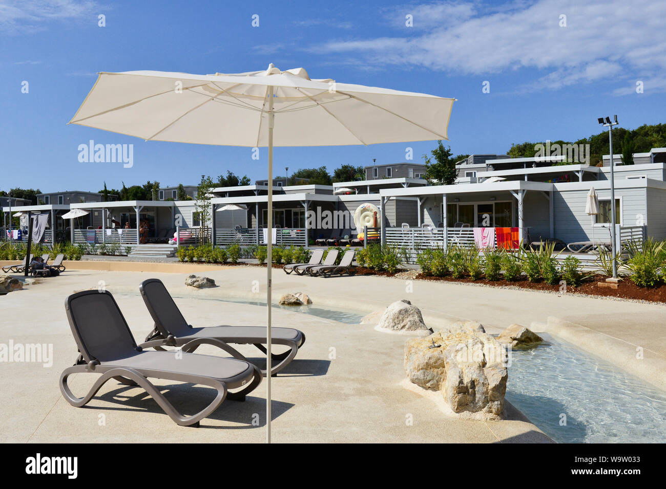 Swimmingpool und Sonnenliegen vor den Bungalows auf dem Campingplatz 'Mobiles Wohnungen Vestar'. Camping Vestar Rovinj, Istrien, Kroatien, Europa Stockfoto