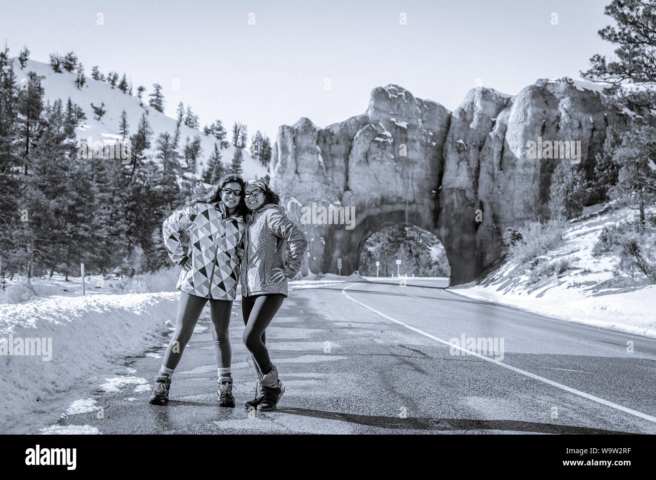 Zwei glückliche Damen neben einem Utah Straße mit einem Tunnel in den Hintergrund stellen. Stockfoto