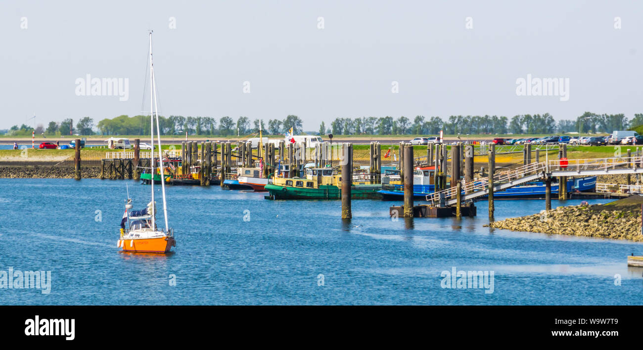 Der Hafen von tholen mit angedockten Schiffe und ein Boot segeln, Bergse diepsluis, Oosterschelde, Zeeland, Niederlande, 22. April 2019 Stockfoto