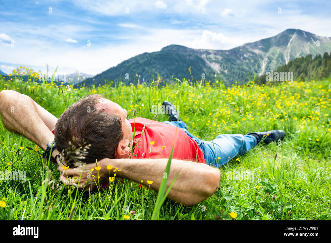 Man Entspannende liegen im Bereich der Gras in den Bergen Stockfoto