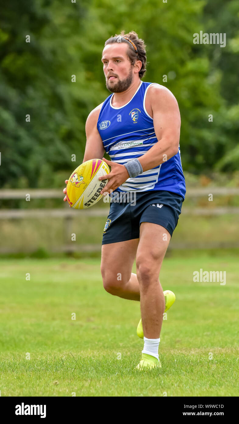 Junger Mann (Alter 20-30) mit Ball in Hand am Bewunderer Touch Rugby Festival in Lowestoft im Juli 2019 Stockfoto