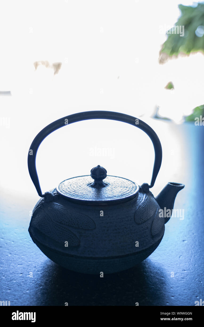 Eine gusseiserne Teekanne auf schwarzem Marmor tisch Stockfoto
