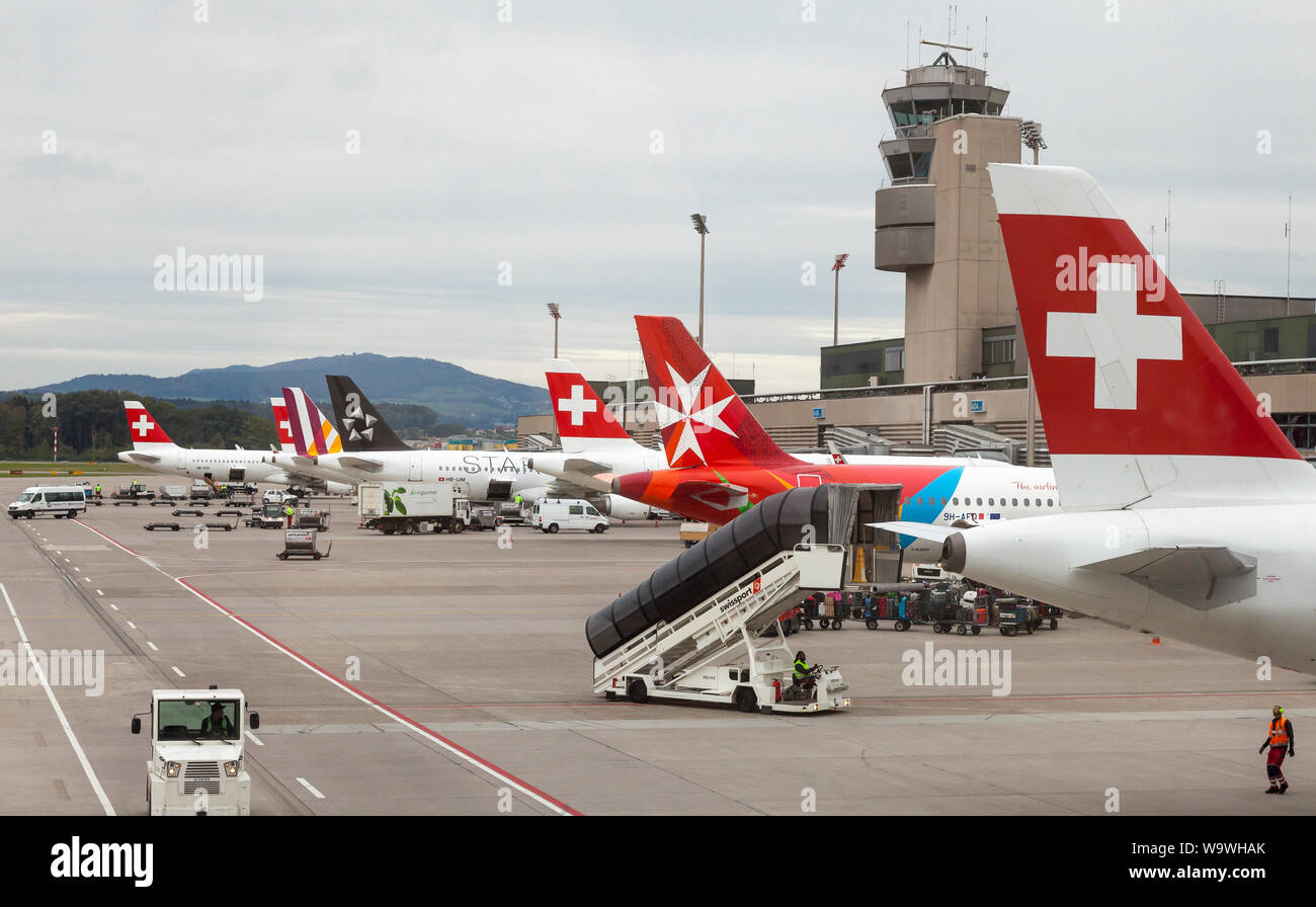 Flugzeuge auftanken und Laden am Flughafen Zürich, Schweiz, der Maltesischen Luft, Swiss Air und Star Alliance Flugzeuge an einem bewölkten winter Eveni Stockfoto
