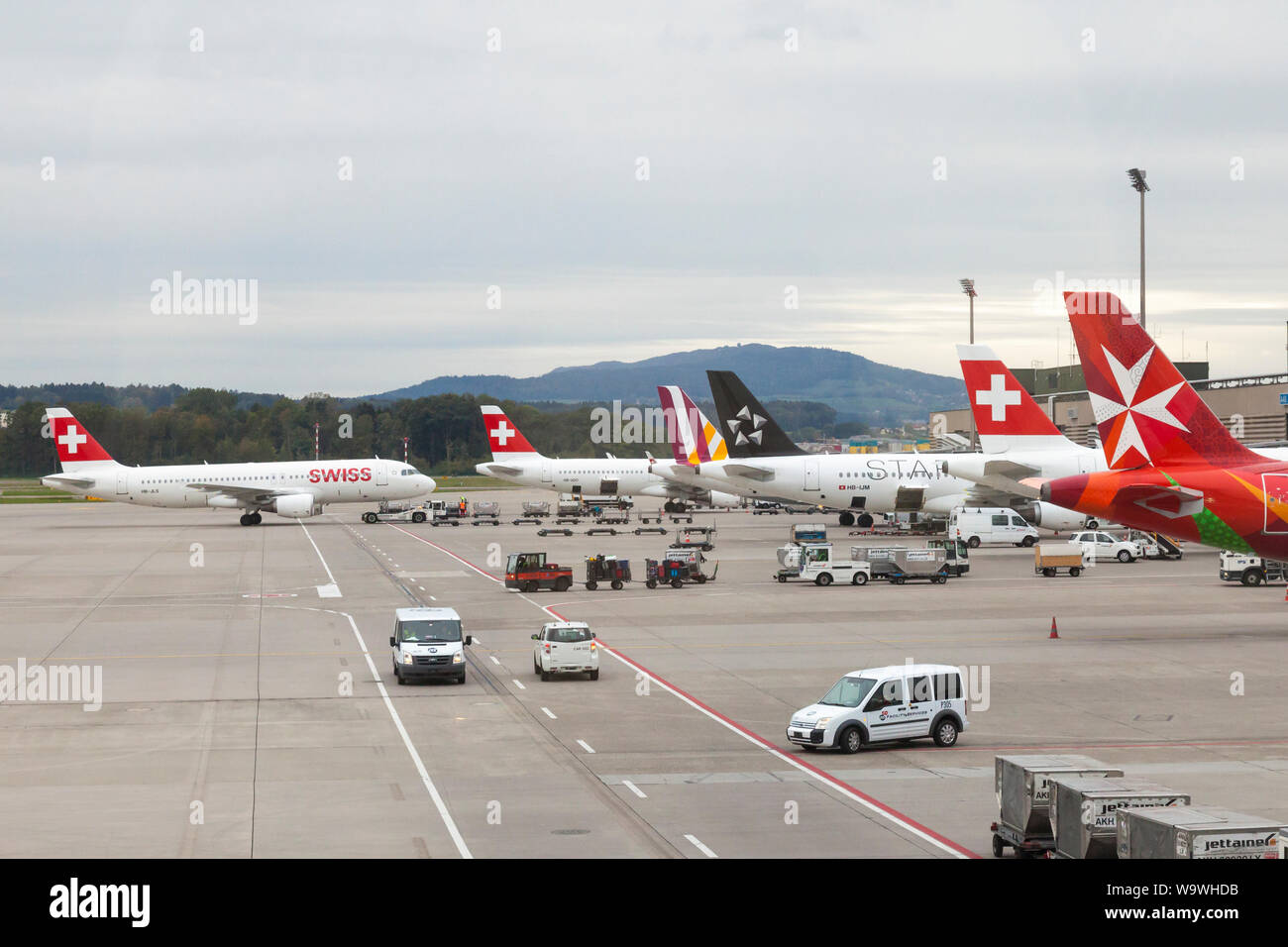Flugzeuge auftanken und Laden am Flughafen Zürich, Schweiz, der Maltesischen Luft, Swiss Air und Star Alliance Flugzeuge an einem bewölkten winter Eveni Stockfoto