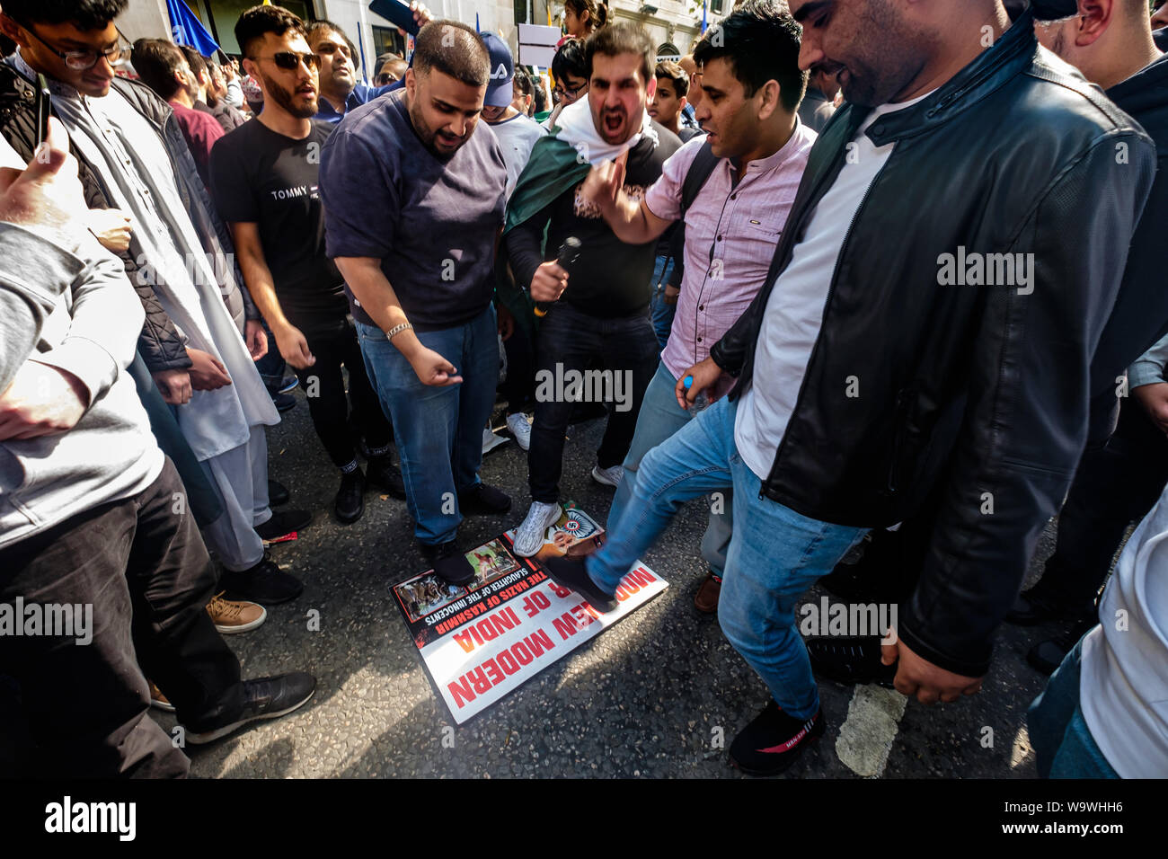 London, Großbritannien. 15. August 2019. Männer Stempel auf ein Bild von Ministerpräsident Modi Verachtung für das Protest außerhalb der Indischen hohe Kommission zu zeigen, Sperrung Aldwych auf der indischen Unabhängigkeit Tag gegen die Verhaftungen und Menschenrechtsverletzungen in Kaschmir. Verschiedene Gruppen kam Präsident der Modi Aufhebung von Artikel 370 der indischen Verfassung zu verurteilen und für die Freiheit für Kaschmir, die seit vielen Jahren von über 700.000 indischen Truppen besetzt wurde. Sie wollen die Rechte des kaschmirischen Volkes respektiert und UN-Resolutionen umgesetzt. Peter Marshall / alamy Leben Nachrichten Stockfoto