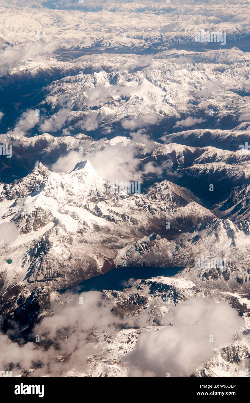 Antenne über den Himalaya der östlichen Tibet, China. Ein Eisfreier See ist im Vordergrund sichtbar. Stockfoto