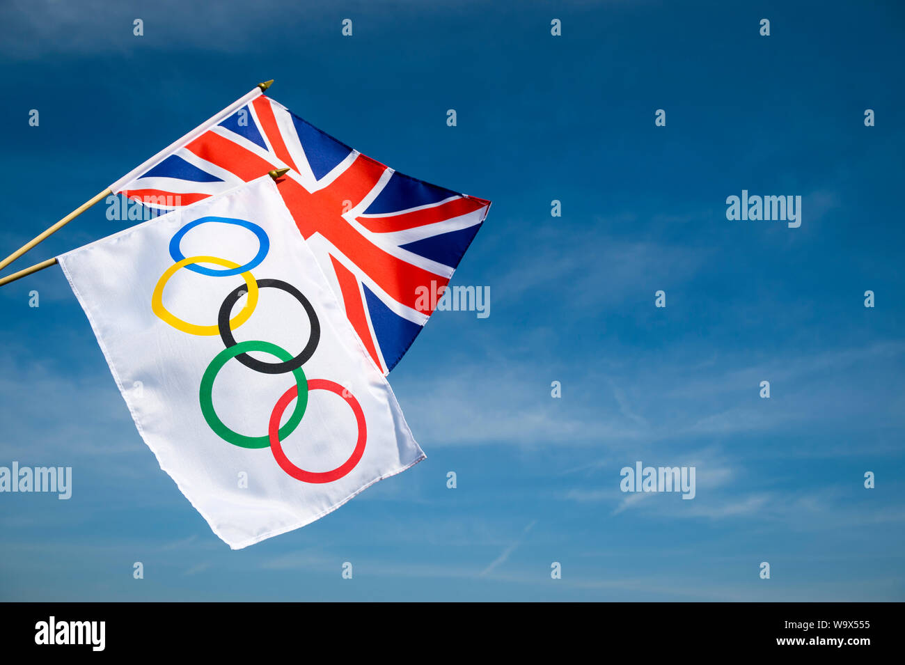 LONDON - 19. APRIL 2019: die Olympischen Spiele und die britischen Flaggen hängen zusammen in den strahlend blauen Himmel. Stockfoto