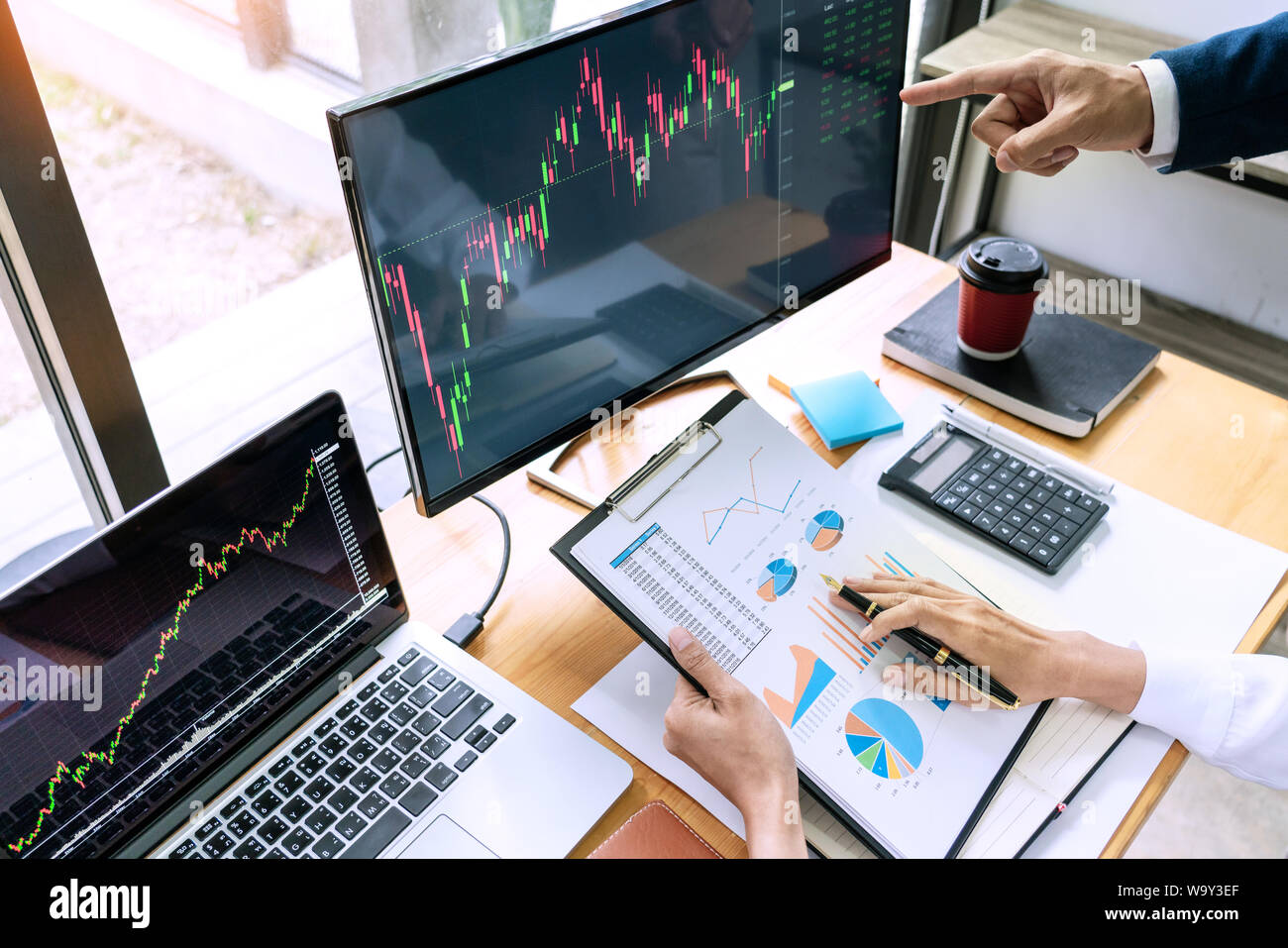 Team von Börsenmaklern diskutiert mit Anzeigen, die Analyse von Daten, Diagramme und Berichte Börsenhandel für Investitionen Stockfoto