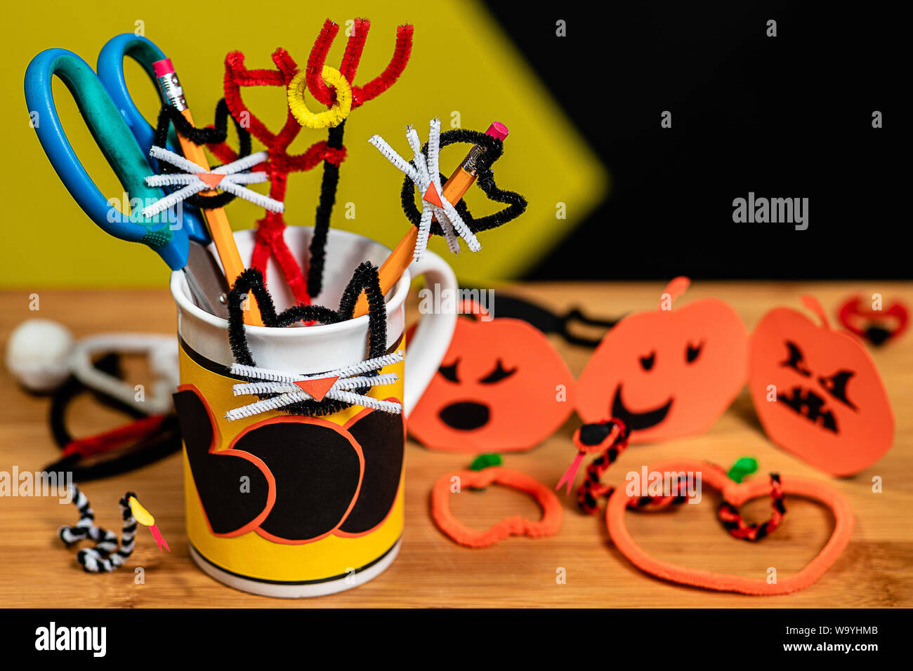 Bürobedarf für Halloween in einem Kaffeebecher dekoriert, dass Boo sagt. Der Tisch ist in anderen Halloween Handwerk abgedeckt. Schlangen und Jack-O-Lant Stockfoto