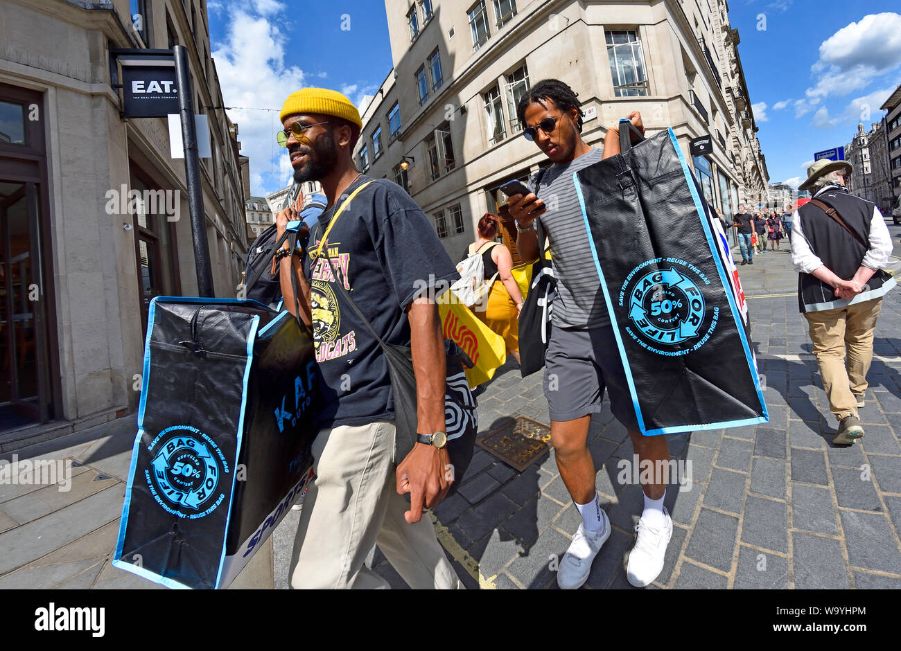 London, England, UK. Zwei Männer mit riesigen Taschen für das Leben Stockfoto