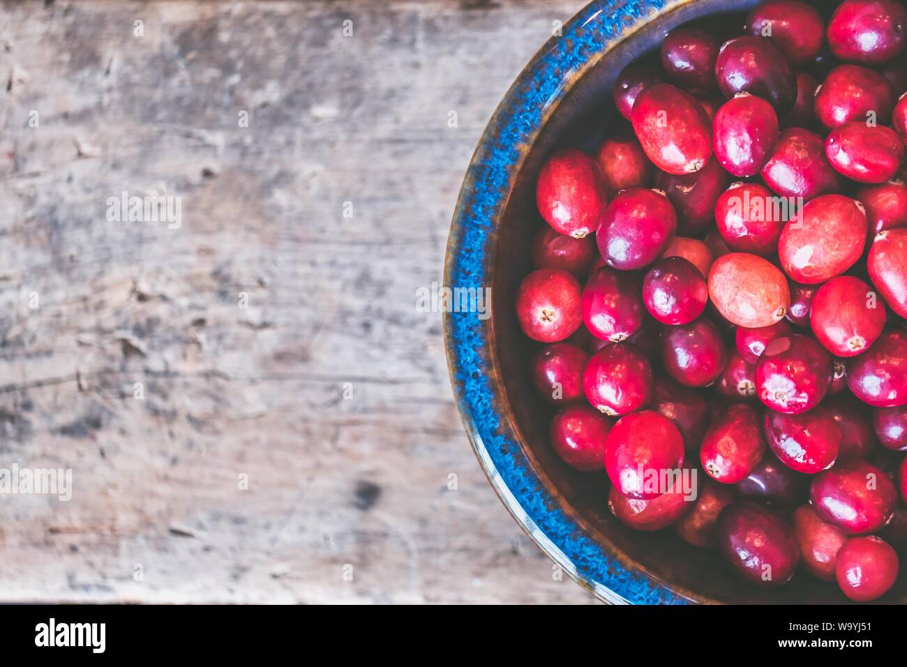 Nahaufnahme von roten Kaffeebohnen auf einem Holzgrau Hintergrund Stockfoto