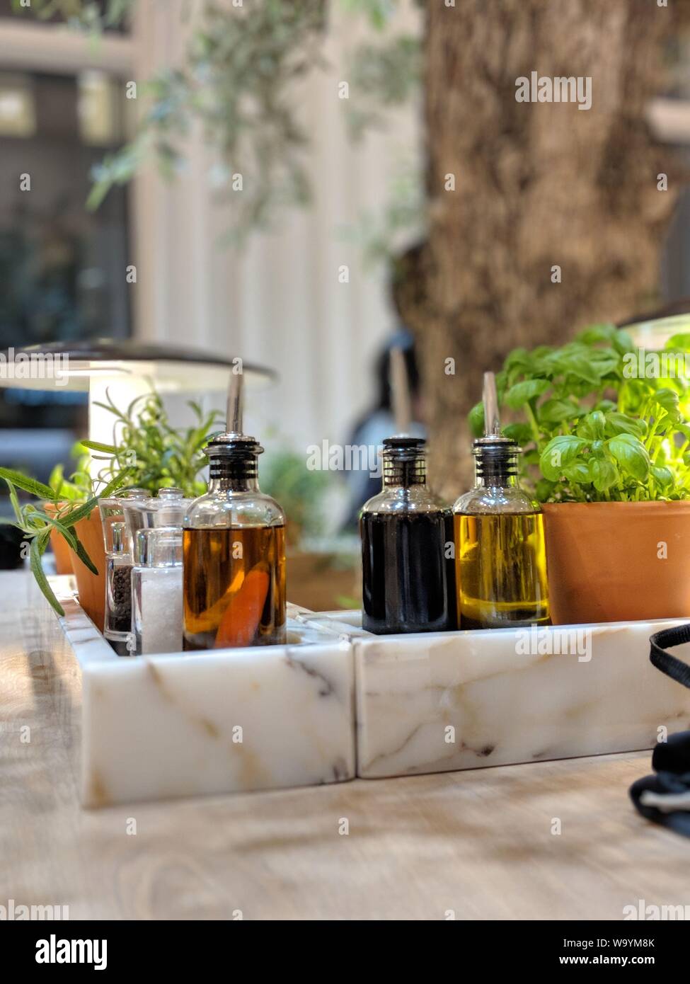 Vertikale Aufnahme von drei Gläsern mit Olive und Schwarz gefüllt Saatöl Stockfoto