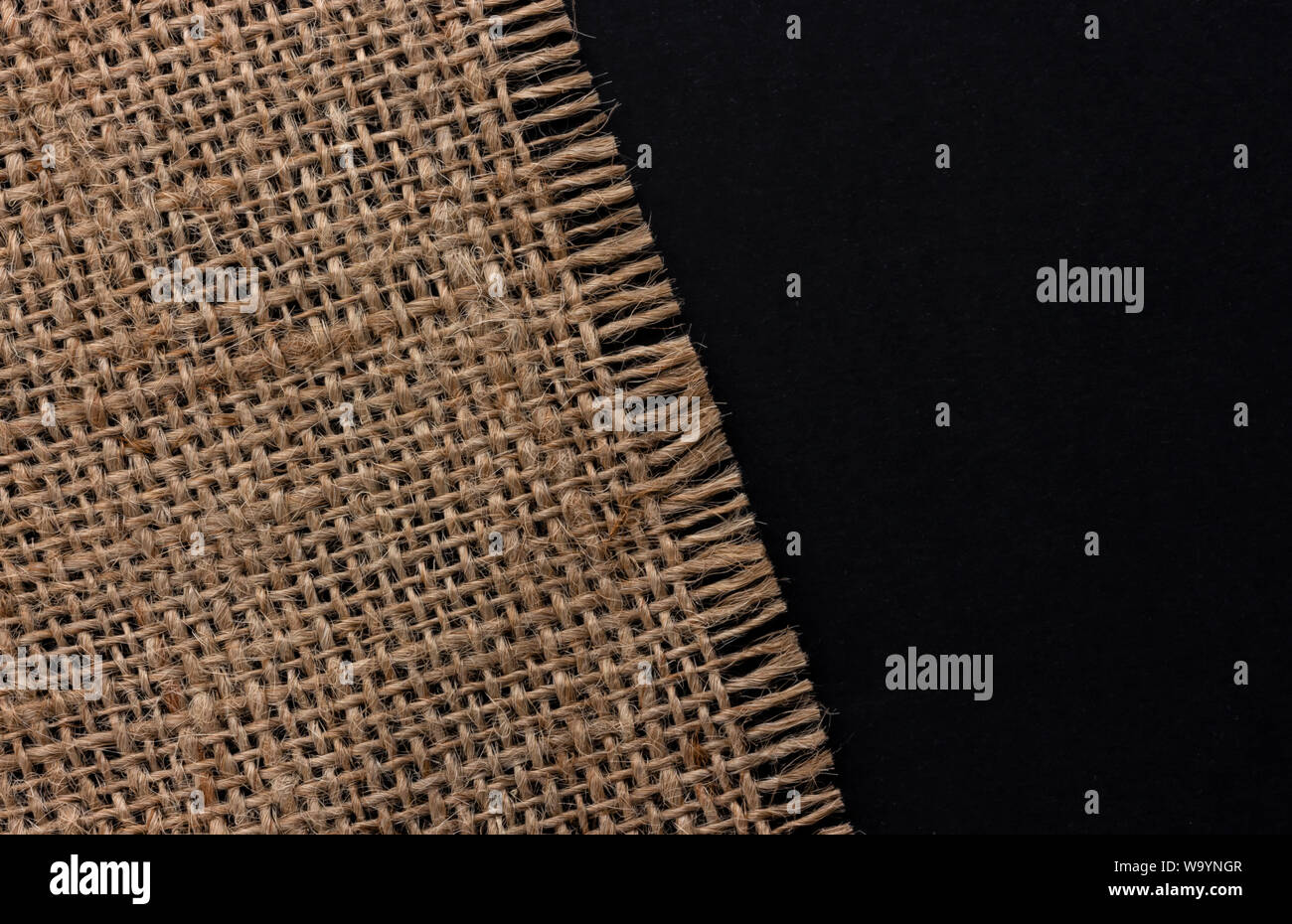 Alte sackleinen Stoff Serviette auf schwarzen Hintergrund, Ansicht von oben Stockfoto