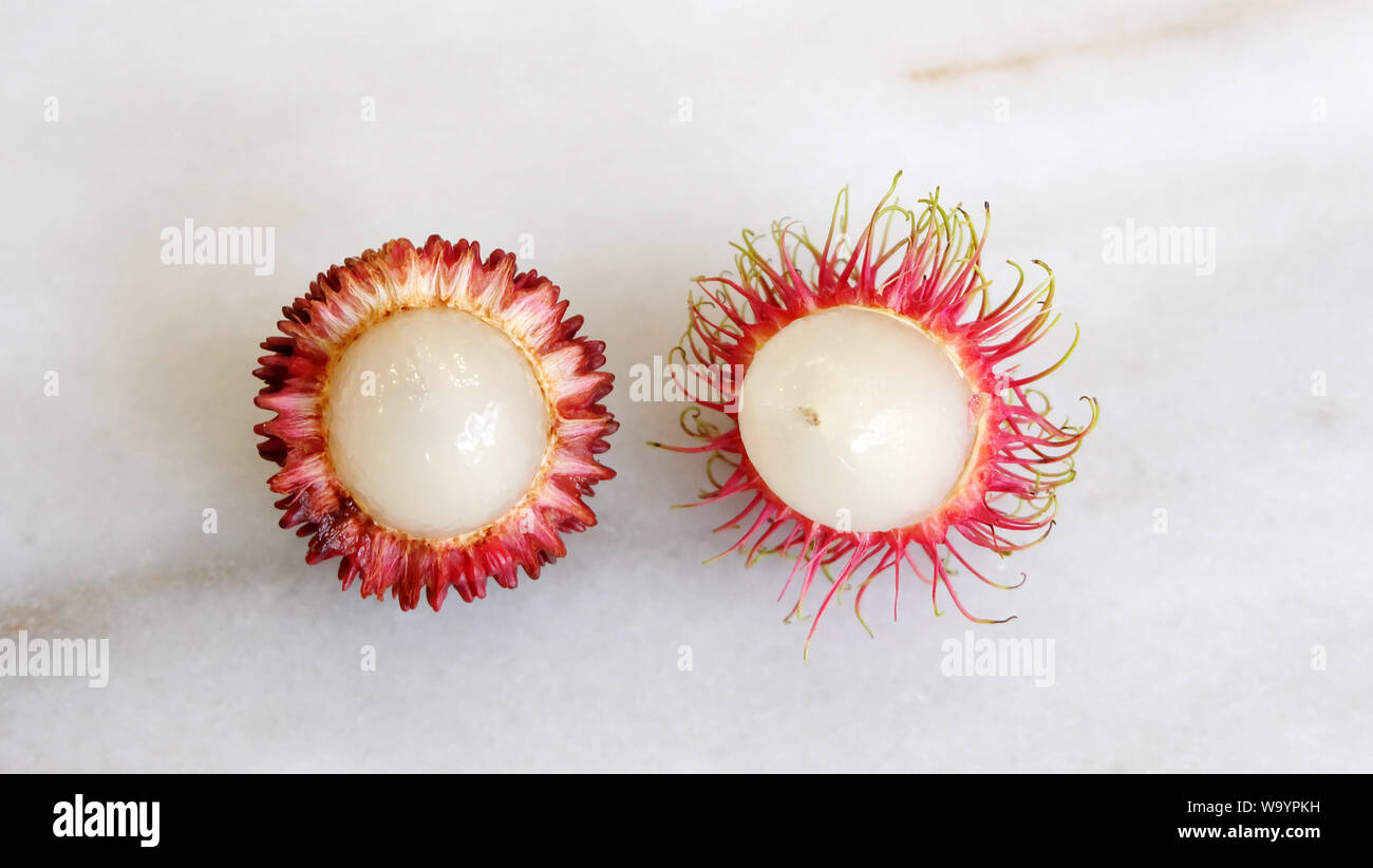 Blick von oben auf die pulasan und rambutan Frucht, nebeneinander angeordneten. Beide sind tropische Früchte aus Südostasien, und manchmal für verwechselt. Stockfoto