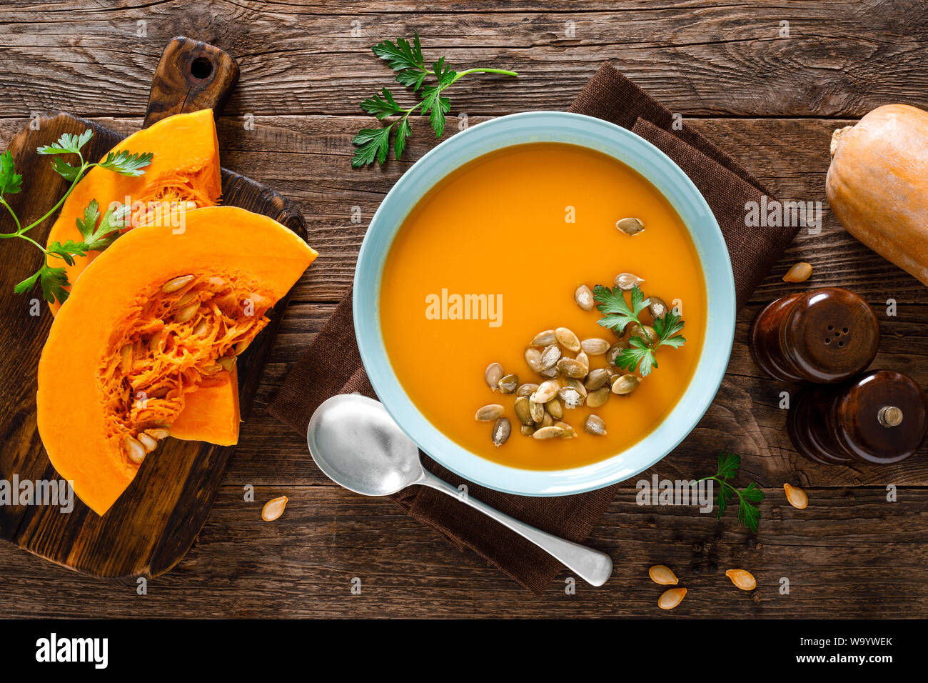 Kürbissuppe. Vegetarische Suppe mit Kürbiskerne in Schale auf Holztisch, Ansicht von oben Stockfoto