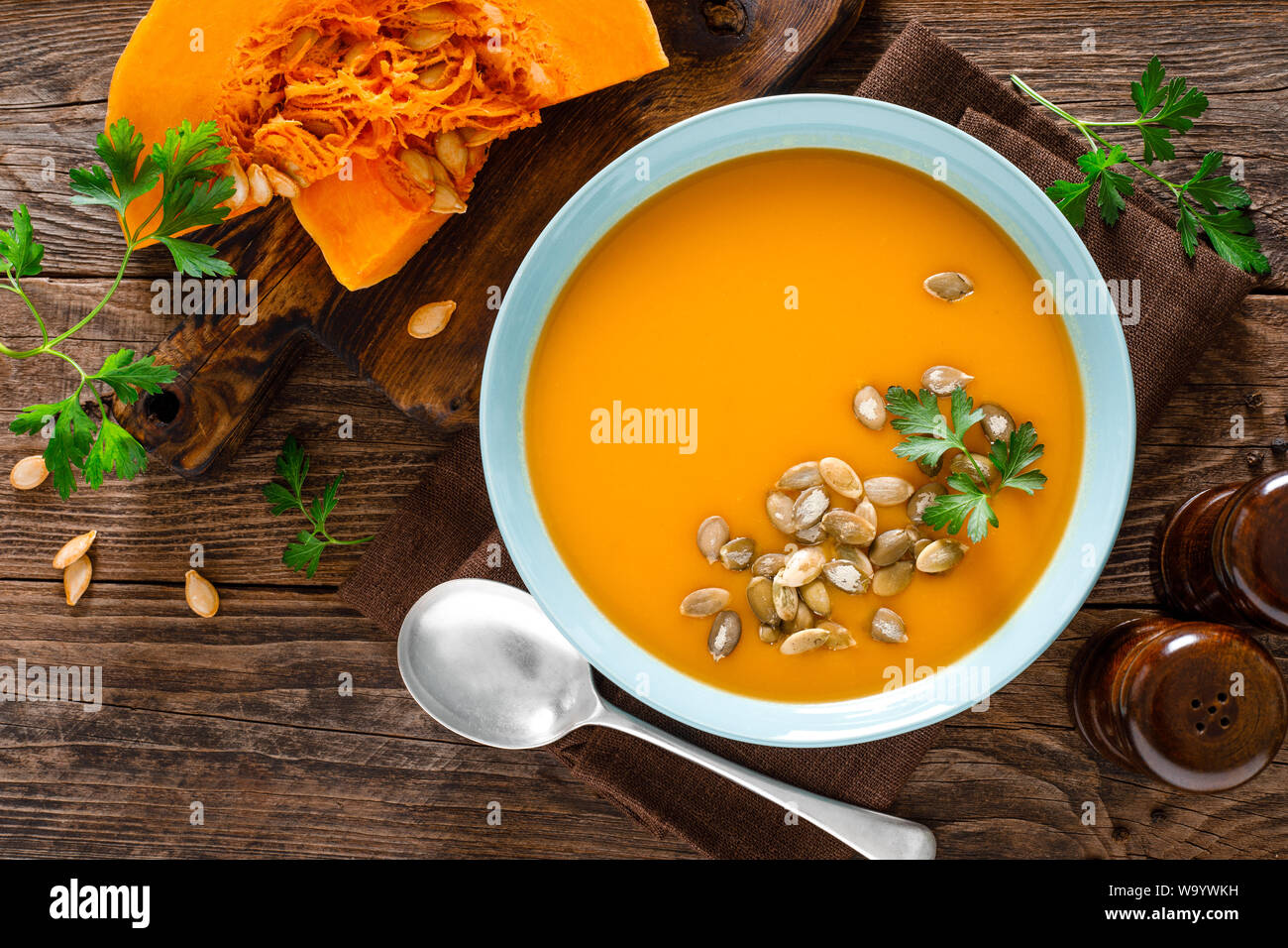 Kürbissuppe. Vegetarische Suppe mit Kürbiskerne in Schale auf Holztisch, Ansicht von oben Stockfoto