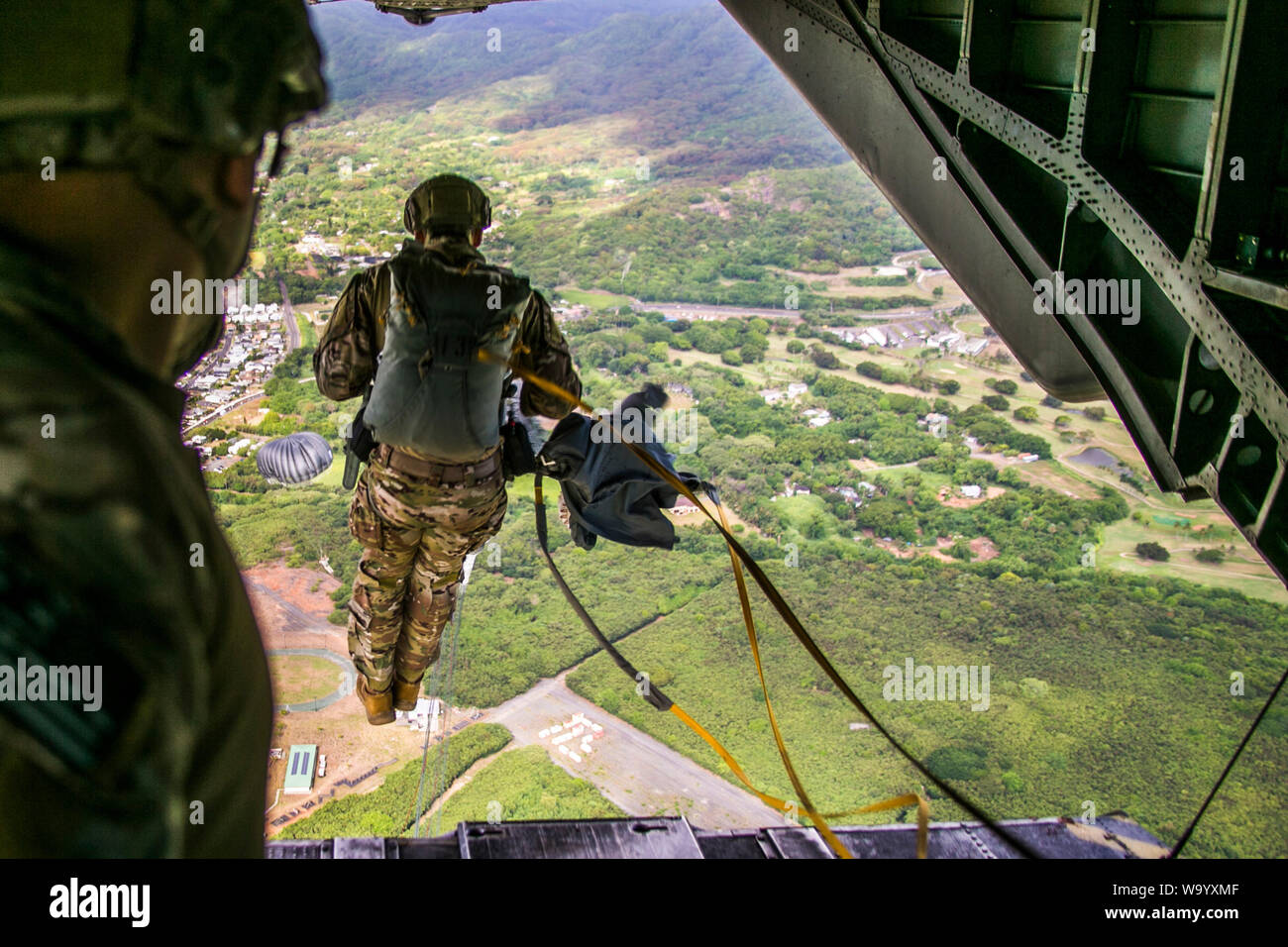 Ein U.S. Armed Service Member springt aus einer CH-53E Super Stallion während Fallschirm Training Operations über Marine Corps Training Bereich Faltenbälge, Hawaii, 14. August 2019. Die Ausbildung von Marine schweren Helikopter Squadron 463, Marine Flugzeuge Gruppe 24 unterstützt, war für den Bewaffneten Service Mitglieder führten ihre Fallschirm Qualifikationsanforderungen zu erhalten. (U.S. Marine Corps Foto von Lance Cpl. Jakob Wilson) Stockfoto