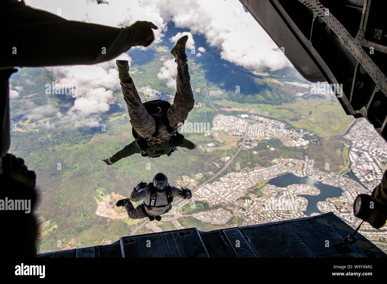 U.S. Armed Service Mitglieder durch ein Tandem-Sprung aus der CH-53E Super Stallion während Fallschirm Training Operations über Marine Corps Training Bereich Faltenbälge, Hawaii, 14. August 2019. Die Ausbildung von Marine schweren Helikopter Squadron 463, Marine Flugzeuge Gruppe 24 unterstützt, war für den Bewaffneten Service Mitglieder führten ihre Fallschirm Qualifikationsanforderungen zu erhalten. (U.S. Marine Corps Foto von Lance Cpl. Jakob Wilson) Stockfoto