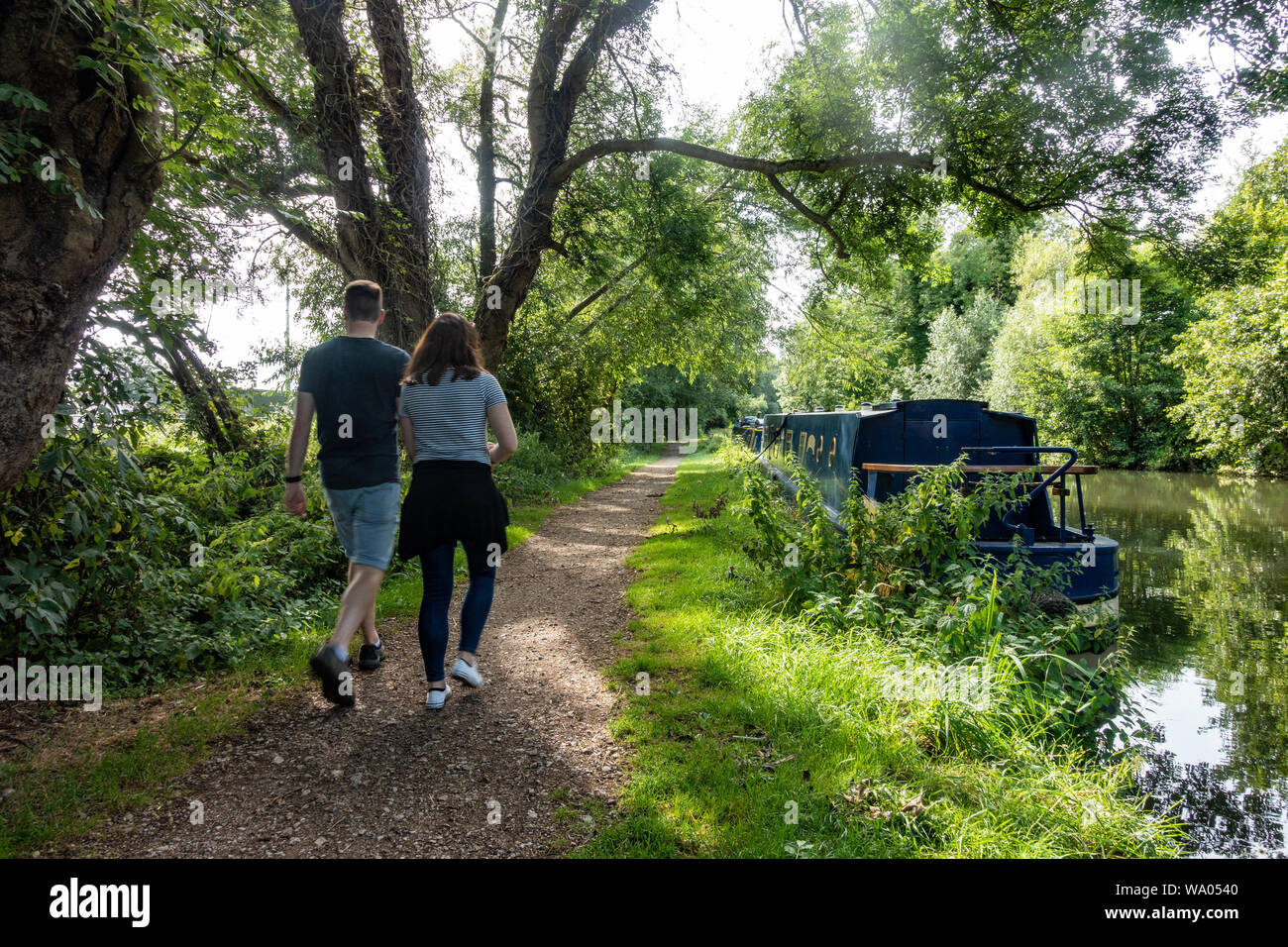 Ein paar für einen Spaziergang in einen Weg entlang der Seite des Flusses Kennet bei Lesung in der Berkshire, Großbritannien Stockfoto