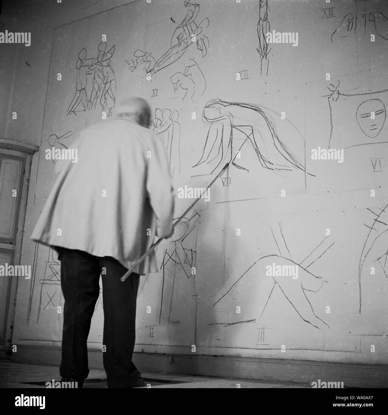 1951, historische, französischen Künstlers Henri Matisse Arbeiten in seinem Atelier auf seine Entwürfe für die Chapelle du Rosaire de Vence (der Rosenkranz Kapelle) eine kleine katholische Kapelle Ferienwohnung. Ein älterer Mann zu dieser Zeit, Matisse verwendet einen langen Stock die Bilder für das Innere der Kapelle auf dem Papier an die Wand zu zeichnen. Stockfoto