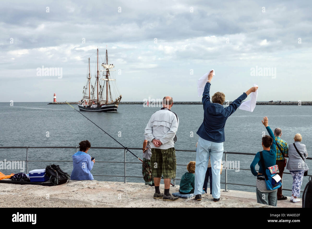 Segelschiff "Thor Heyerdahl", die Menschen begrüßen das Schiff in den Hafen von Rostock, Deutschland Stockfoto