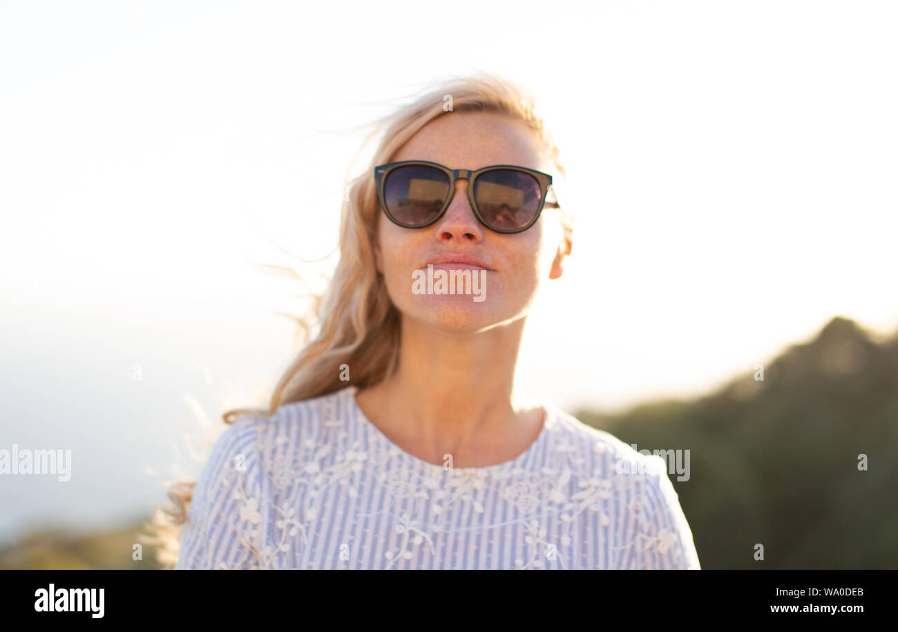 Junge blonde Natürliche kaukasische Frau in Sonnenbrille portrait draußen in der Natur Stockfoto