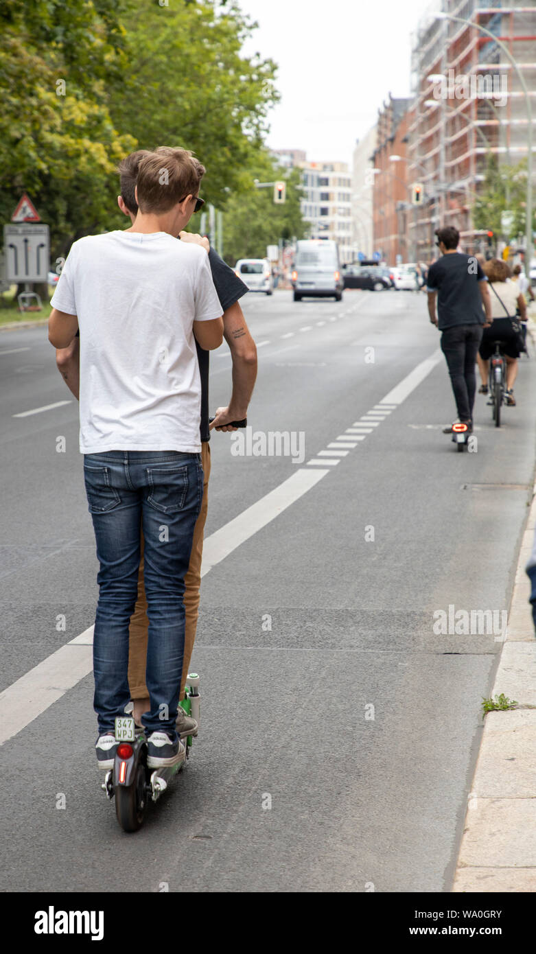 E-Scooter, Elektro Roller, Scooter, in Berlin, fahren am Straßenrand,  Bürgersteig, MŸhlenstrasse, Friedrichshain, zwei Leute auf einem  Motorroller Stockfotografie - Alamy