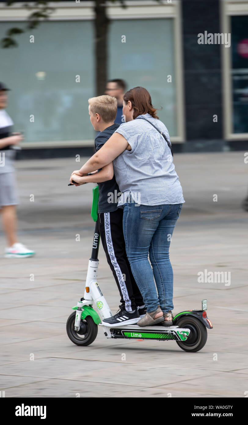 E-Scooter, Elektro Roller, Roller, Fahren, am Alexander Platz in Berlin,  zwei Leute auf einem Motorroller Stockfotografie - Alamy