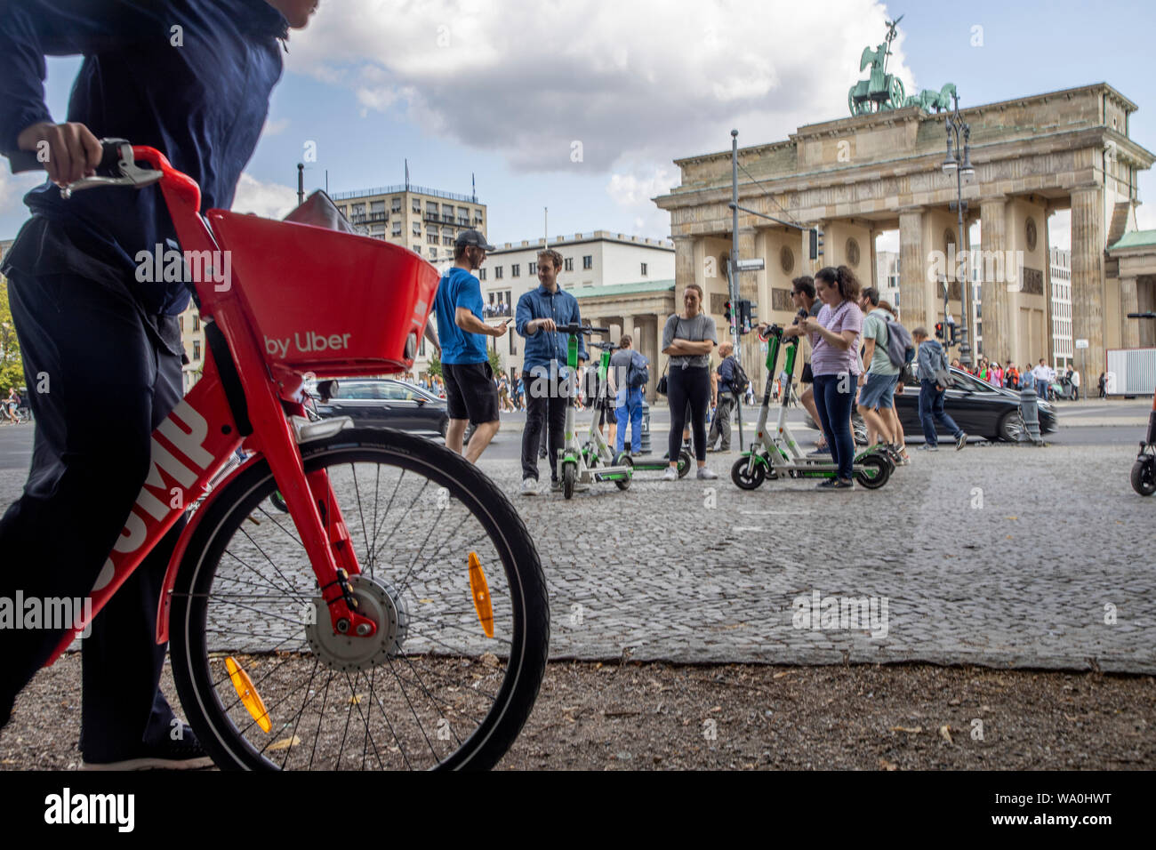 Mann mit Vermietung e-Bike von Uber, Elektroroller, Elektroscooter, Elektroroller, vor dem Brandenburger Tor in Berlin. Stockfoto