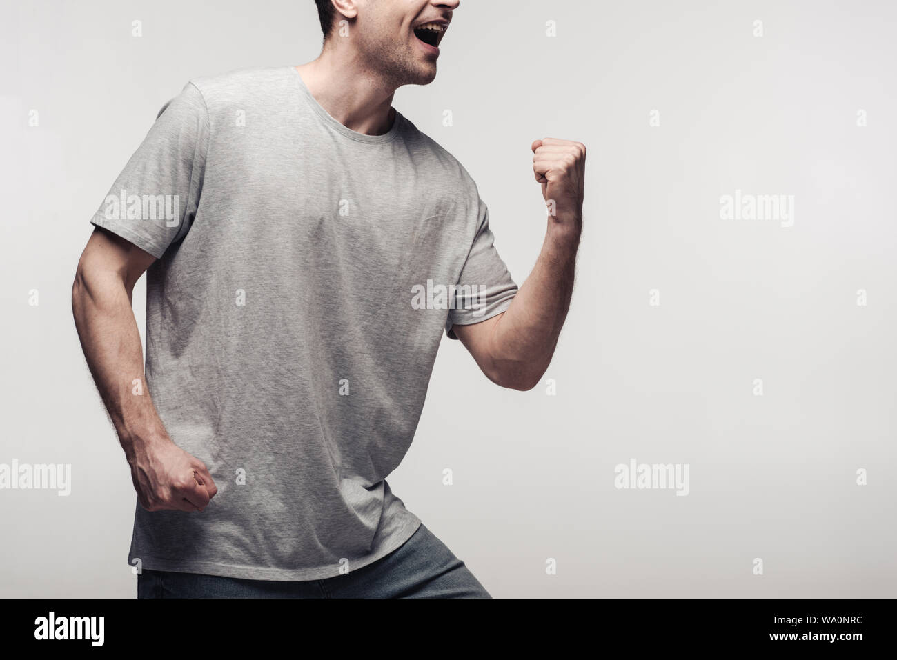 Aufgeregt Mann, Sieger Geste auf grau, menschliche Emotion und Expression Konzept isoliert Stockfoto