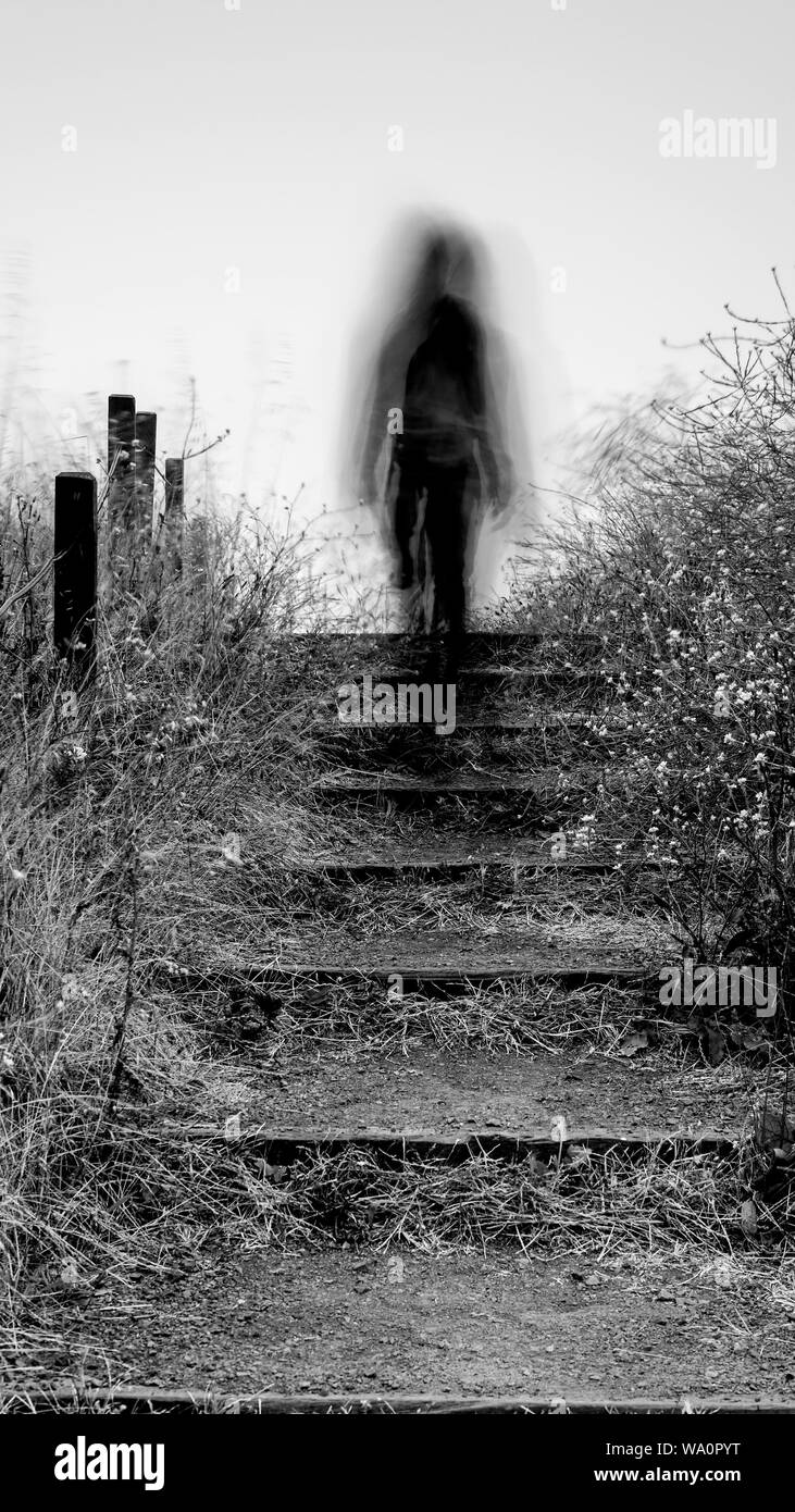 Ghost in der Nähe der Treppen in Schwarz und Weiß - Spooky Halloween oder Thriller Zusammensetzung Stockfoto