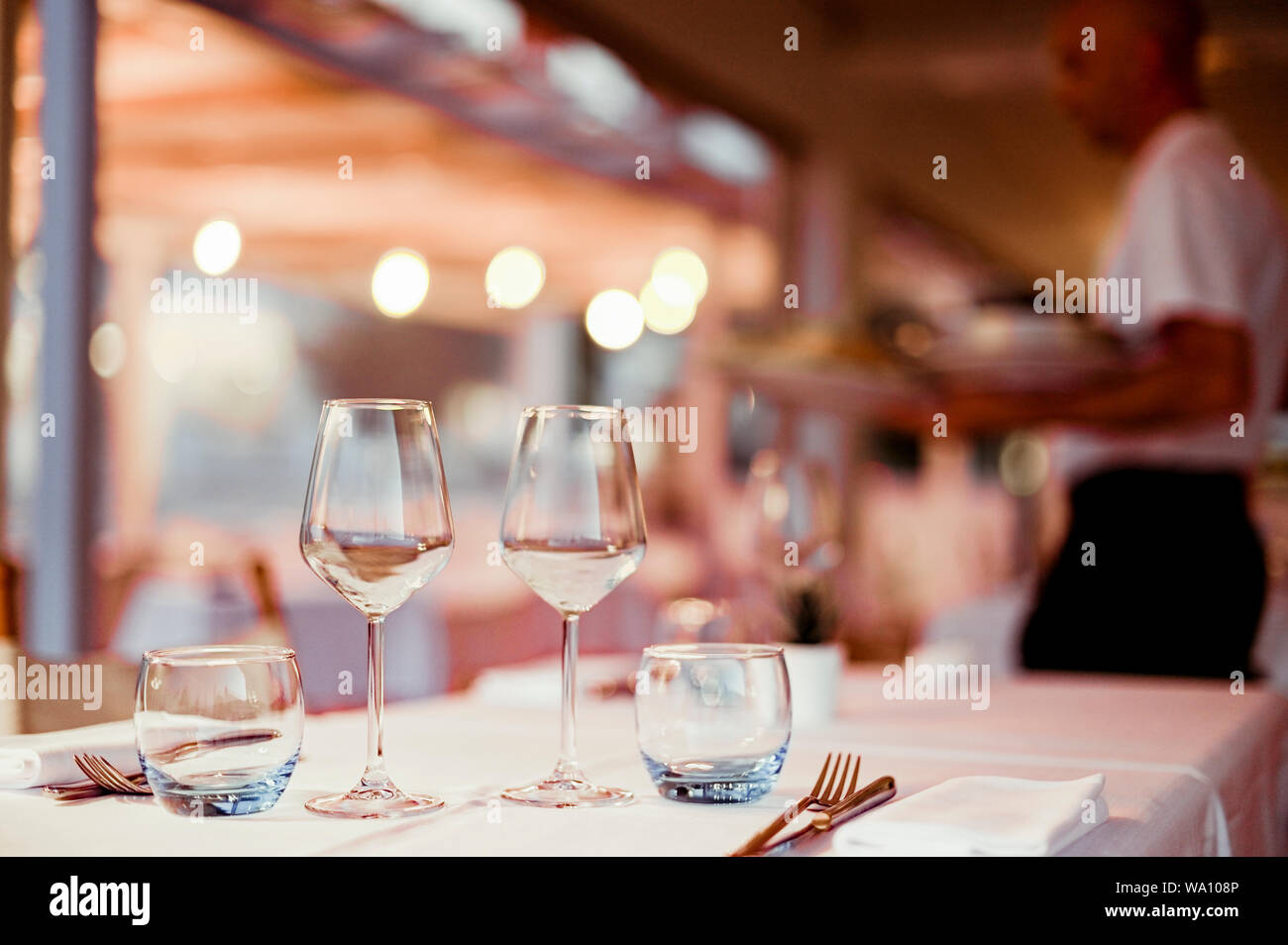 Ein Glas Weisswein auf einen Tisch im Restaurant. Getönten Foto. Blendung und leichte Flecken. Freier Platz für Text Stockfoto