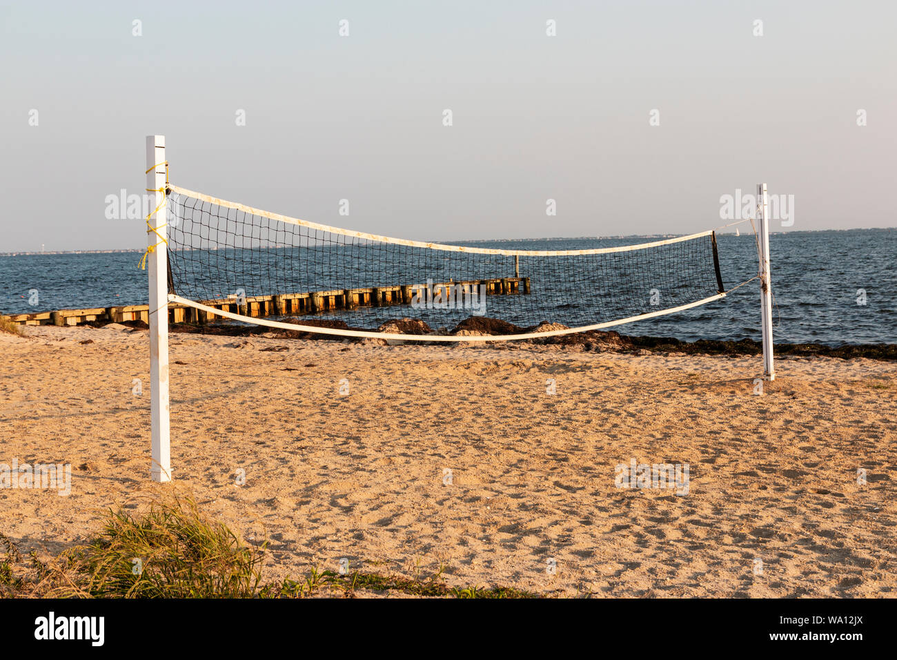 Ein Beach Volleyball net ist bis auf einen leeren Strand am Wasser auf Long Island. Stockfoto