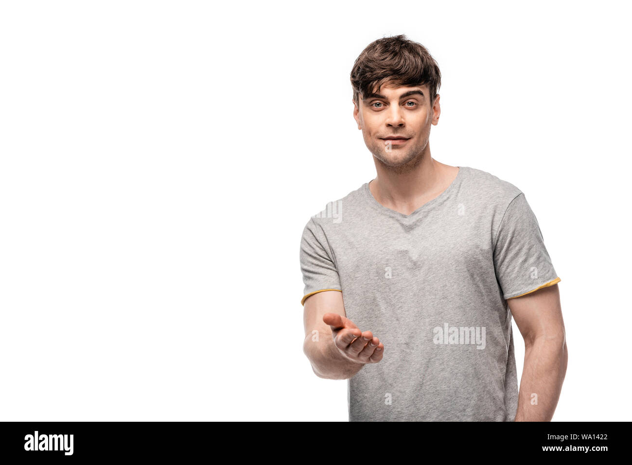 Hübscher junger Mann mit ausgestreckten Hand an der Kamera isoliert auf weißem suchen Stockfoto