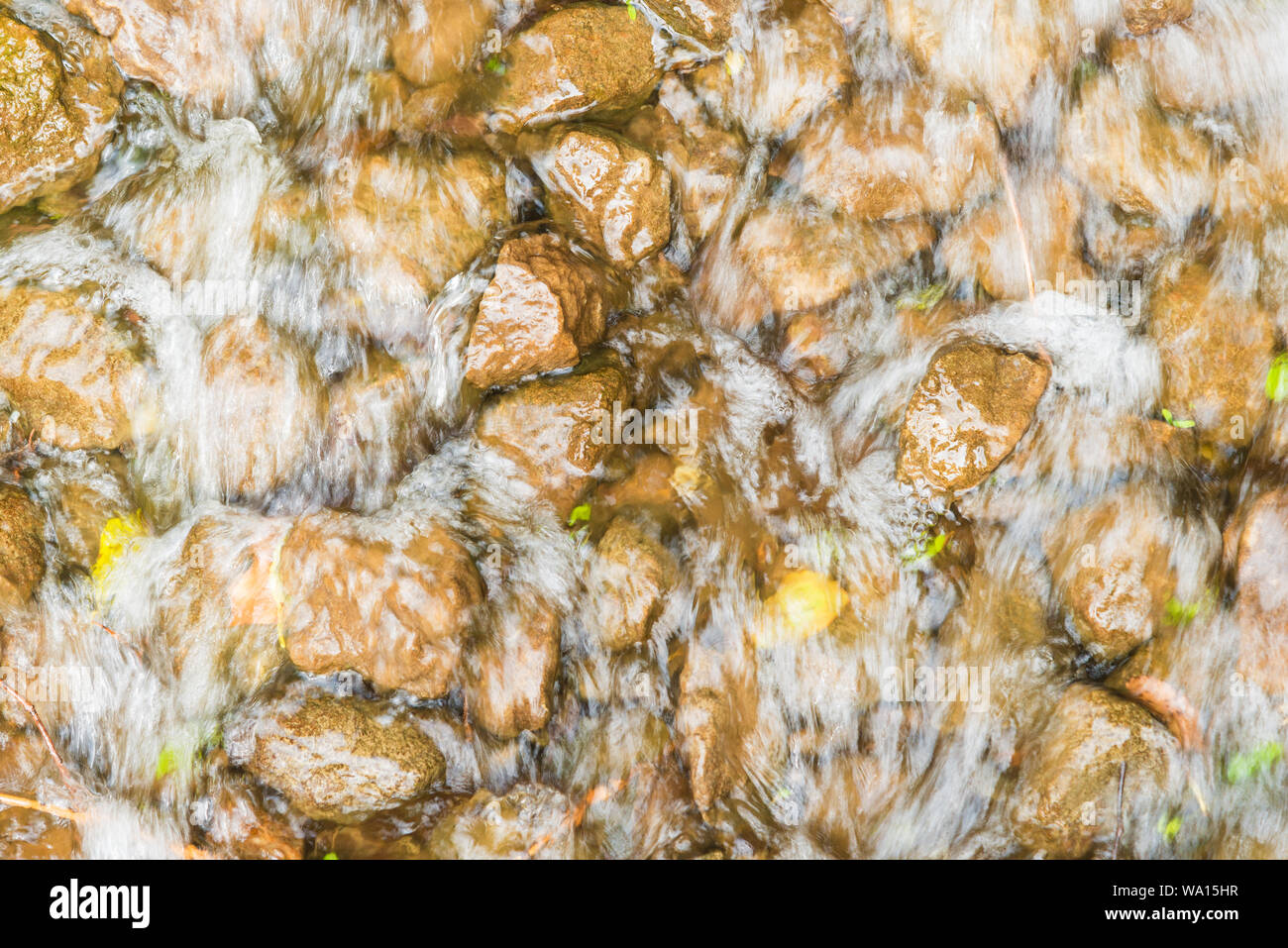 Strom fließt durch die Felsen im Hintergrund Stockfoto