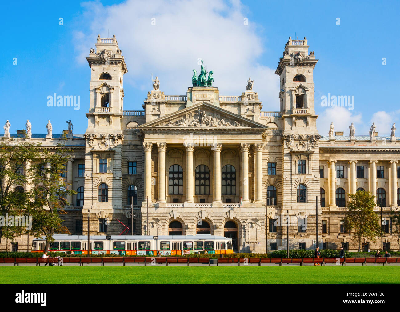 Kossuth tér mit gelben Straßenbahn und einen direkten Blick auf das Ethnographische Museum Gebäude an einem sonnigen Nachmittag. Budapest, Ungarn. Stockfoto